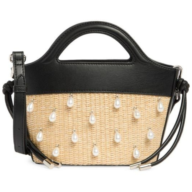 A woven beige handbag with black leather accents and pearl-like embellishments, featuring a top handle and adjustable shoulder strap.