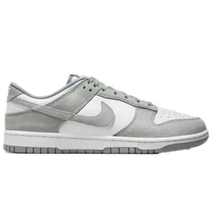 A pair of gray and white low-top sneakers with suede and leather details, featuring the Nike logo on the sides.