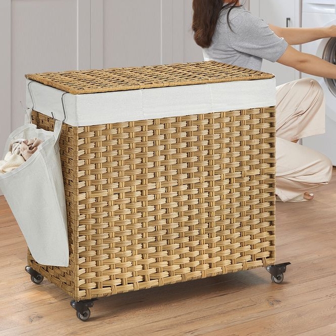 A 160L wicker laundry hamper with a cushioned lid and side pocket, mounted on wheels for mobility.