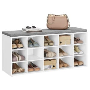 White shoe storage bench with a cushioned top, holding various shoes, a beige handbag, sunglasses, and two books.