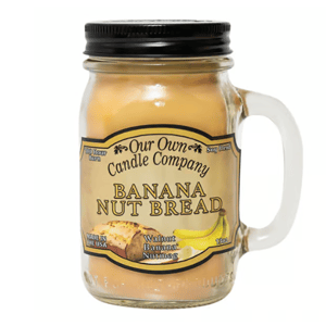 Our Own Candle Company Banana Nut Bread scented candle in a mason jar with a handle, featuring notes of walnut, banana, and nutmeg.