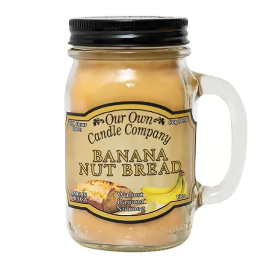 Our Own Candle Company Banana Nut Bread scented candle in a mason jar with a handle, featuring notes of walnut, banana, and nutmeg.