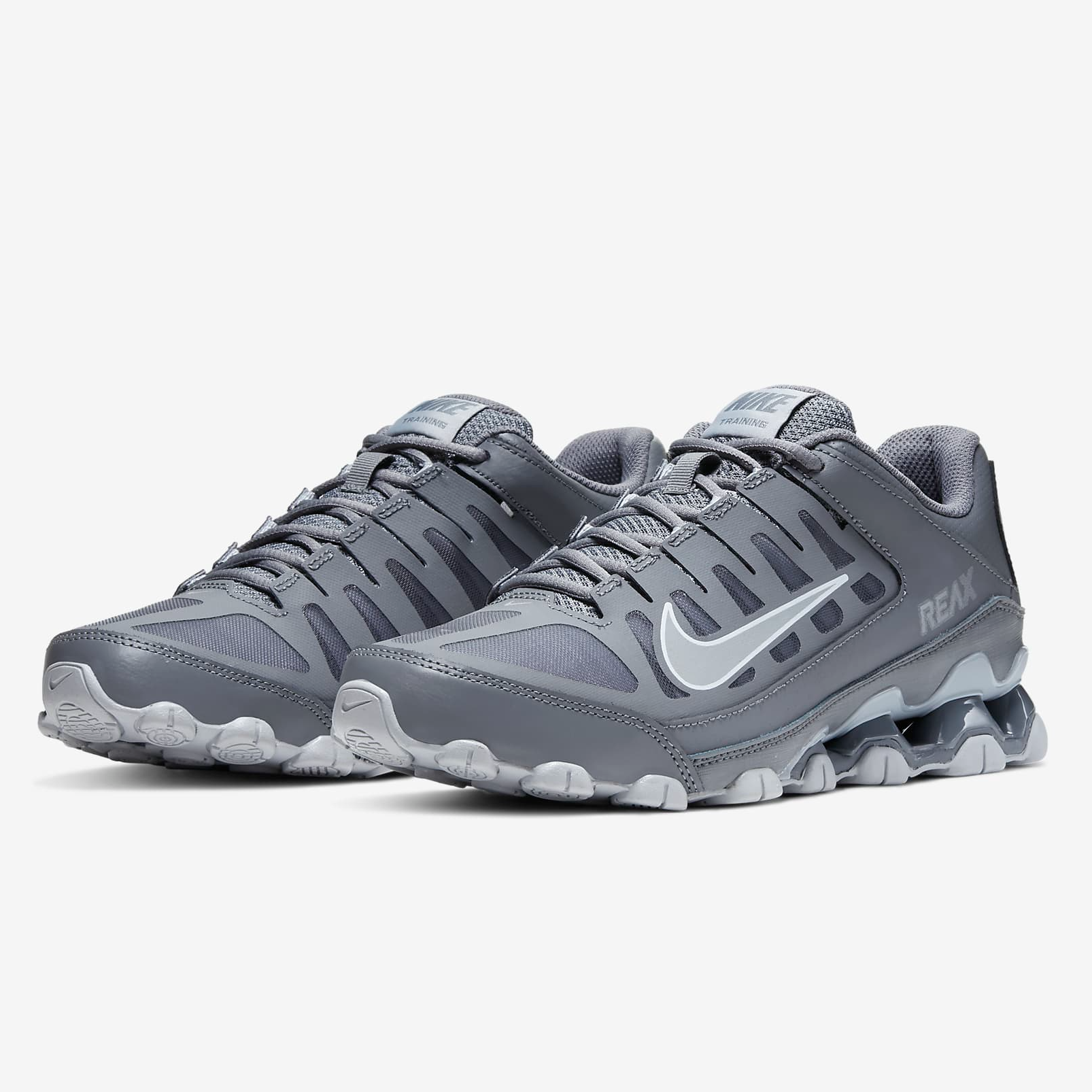 Gray Nike Reax 8 TR men's shoes with a white swoosh and cushioned soles designed for training.
