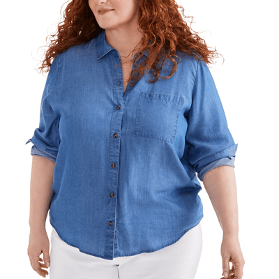 A person is wearing a blue denim button-up shirt with rolled-up sleeves and white pants.