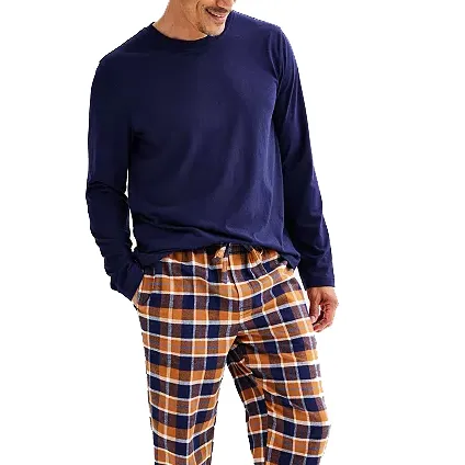 A person is wearing a navy long-sleeve shirt paired with brown and blue plaid pajama pants.