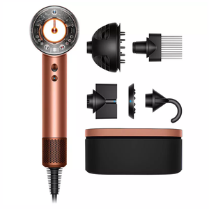 A copper-colored hair dryer with various attachments, including a diffuser, wide-tooth comb, smoothing nozzle, gentle air attachment, and storage case.
