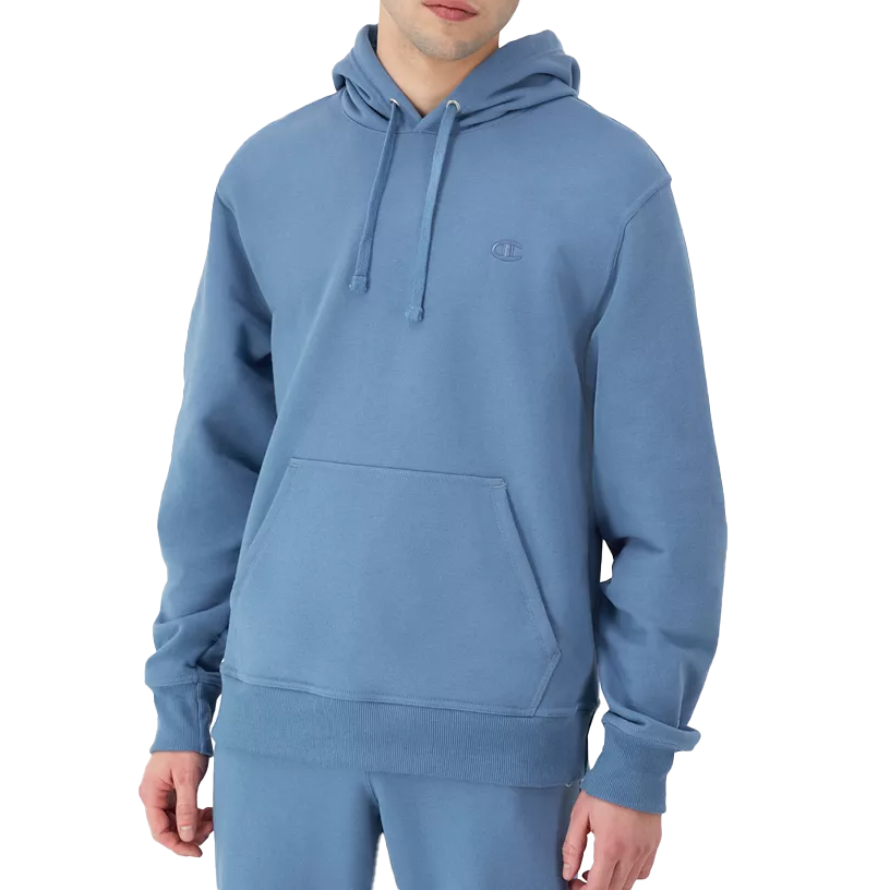 A person wearing a light blue hoodie with a front pocket and drawstring hood, featuring a small embroidered logo on the chest. Matching pants are also visible.