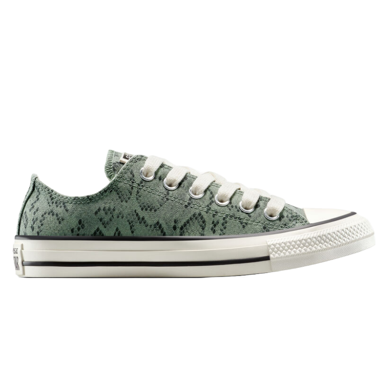 A low-top sneaker with a green snakeskin pattern, white toe cap, and beige laces, featuring a thick sole with black trim and a textured toe bumper.