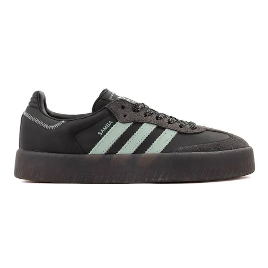 A black Adidas Samba sneaker with mint green stripes, thick black sole, and a textured toe area.