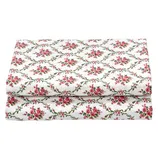Folded floral-patterned fabric with pink roses and green vines on a white background.