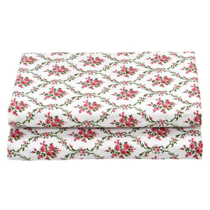 Folded floral-patterned fabric with pink roses and green vines on a white background.