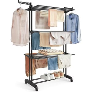 A multi-tiered metal clothing rack for drying, featuring several bars and shelves holding various garments, towels, and shoes. It includes hanger attachments and sits on caster wheels for mobility.