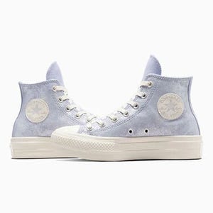 A pair of high-top canvas sneakers in a pale blue color with white laces and rubber soles.