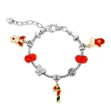 A silver charm bracelet features red and green holiday-themed charms, including a snowman, mitten, and candy cane, with red gemstone accents.