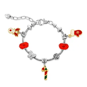 A silver charm bracelet features red and green holiday-themed charms, including a snowman, mitten, and candy cane, with red gemstone accents.