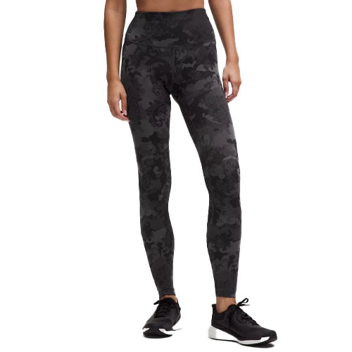 High-waisted leggings with a black camouflage pattern paired with black athletic shoes.