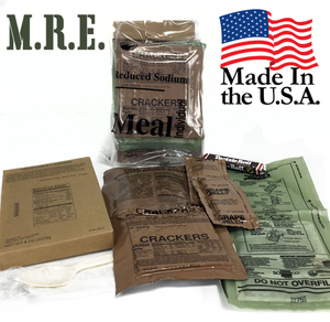 MRE (Meal, Ready-to-Eat) packets with various contents such as crackers and beverage mix, labeled as made in the USA.