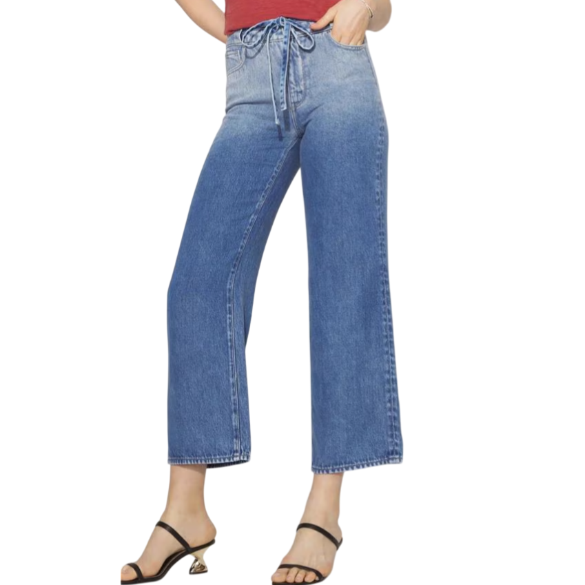 High-waisted, wide-leg blue jeans with a lace-up front tie, paired with black strappy sandals featuring a gold heel detail.