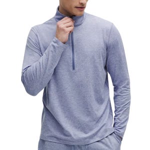 A person is wearing a light blue long-sleeve quarter-zip top.