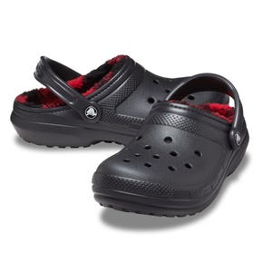 Black slip-on clogs with a red and black fleece lining, featuring ventilation holes and adjustable heel straps.