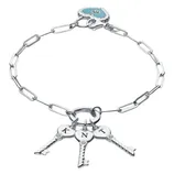 A silver bracelet features a paperclip chain with three key charms, each engraved with a letter (K, N, T). It also includes a turquoise heart charm with a sparkling accent.