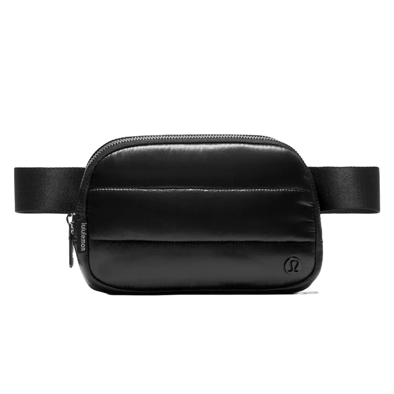 Lululemon Wunder Puff Shine Belt Bag in black features a quilted design with a sleek, shiny finish, adjustable strap, and zippered compartment, offering a stylish and functional accessory for carrying essentials.