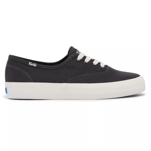 A black canvas sneaker with white laces and a white rubber sole, labeled \“Keds\“ on the side.