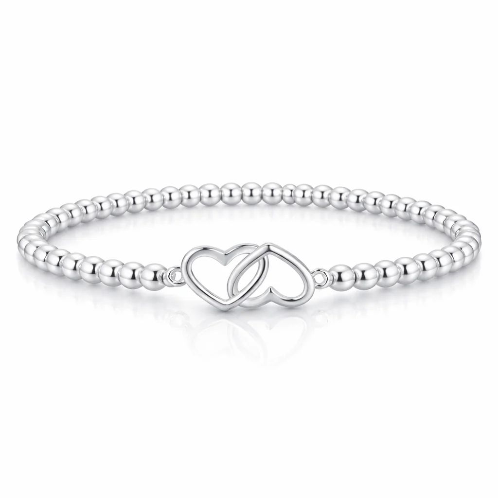 A silver bracelet featuring small round beads and an intertwined double heart charm centerpiece.