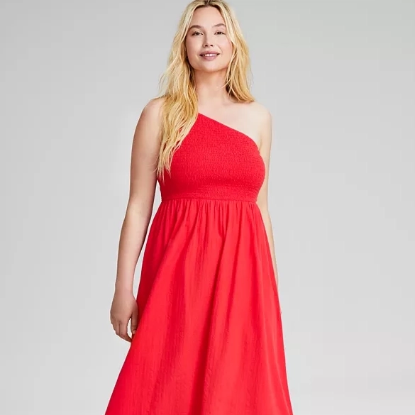 A woman wearing a red one-shoulder maxi dress with a fitted bodice and flowing skirt.
