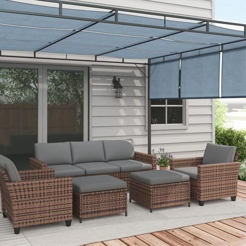 Outdoor patio set with wicker furniture, including a sofa, two chairs, and ottomans with gray cushions, paired with a blue retractable pergola canopy.