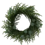 A decorative wreath made of lush, green fir branches and round eucalyptus leaves.