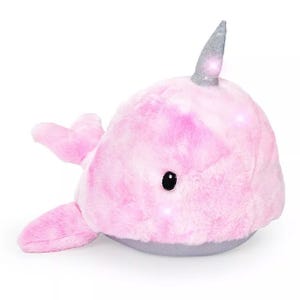 A pink plush narwhal toy with a sparkling silver horn and small black eyes.