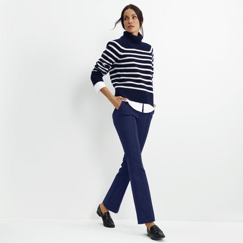 Navy blue bootcut pants with a mid-rise fit and slight flare at the hem, paired with a striped sweater and loafers.