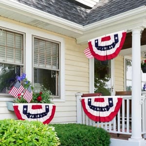 Red, white, and blue bunting with stars hanging on a house's porch railings and window, evoking a patriotic theme.
