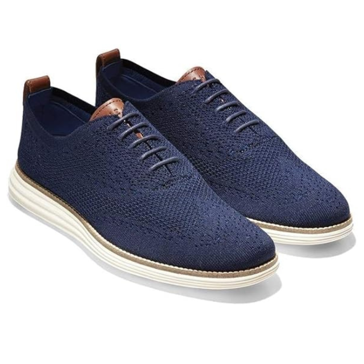 Cole Haan Original Grand Sneakers feature a navy knit upper with a sleek lace-up design, leather accents, and a contrasting white sole for a modern casual look.