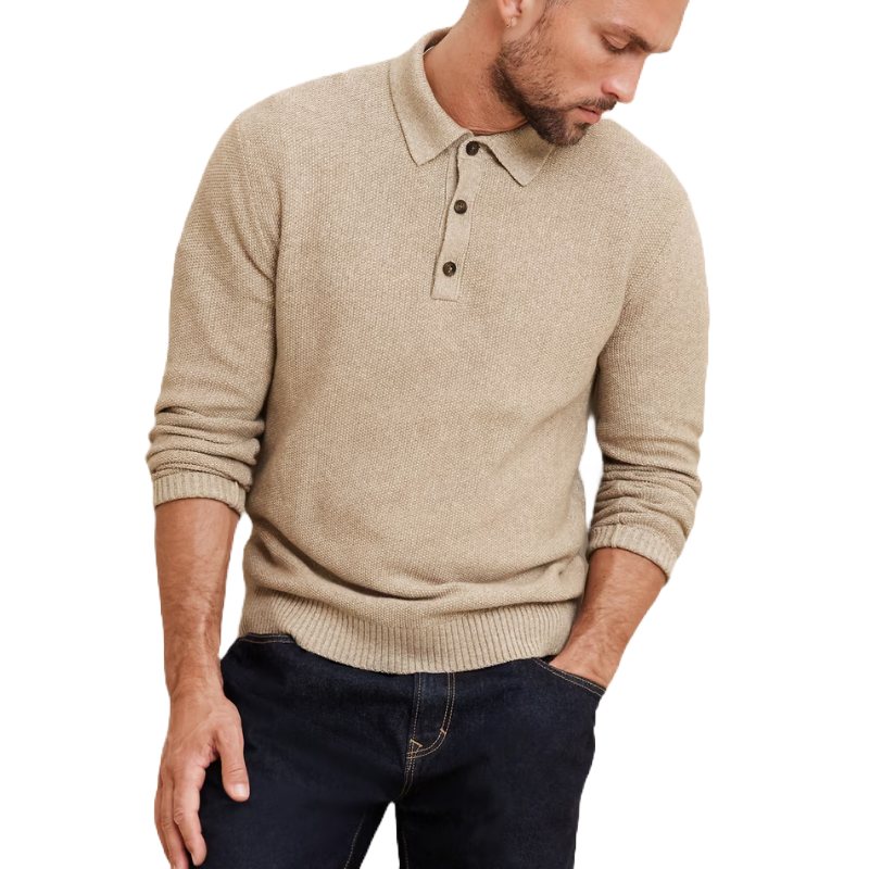 A beige seed stitch polo sweater with long sleeves, ribbed cuffs, and a collar featuring a three-button placket, paired with dark blue jeans.