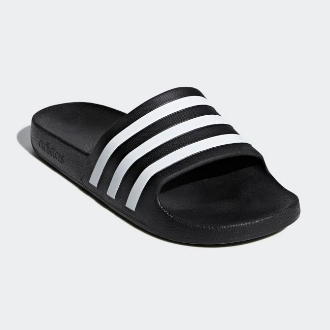A single black slide sandal with three white stripes across the strap.