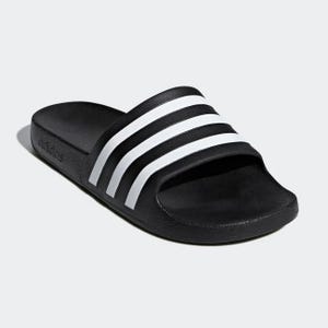 A single black slide sandal with three white stripes across the strap.