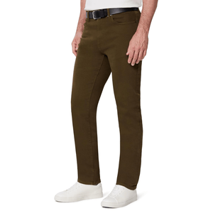 A man is wearing slim-fit brown trousers with a black belt and white sneakers.