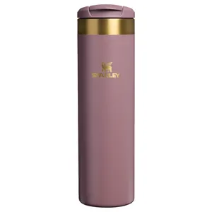 Tall, stainless steel travel mug in rose color with gold accents, featuring a flip-top lid and Stanley logo.