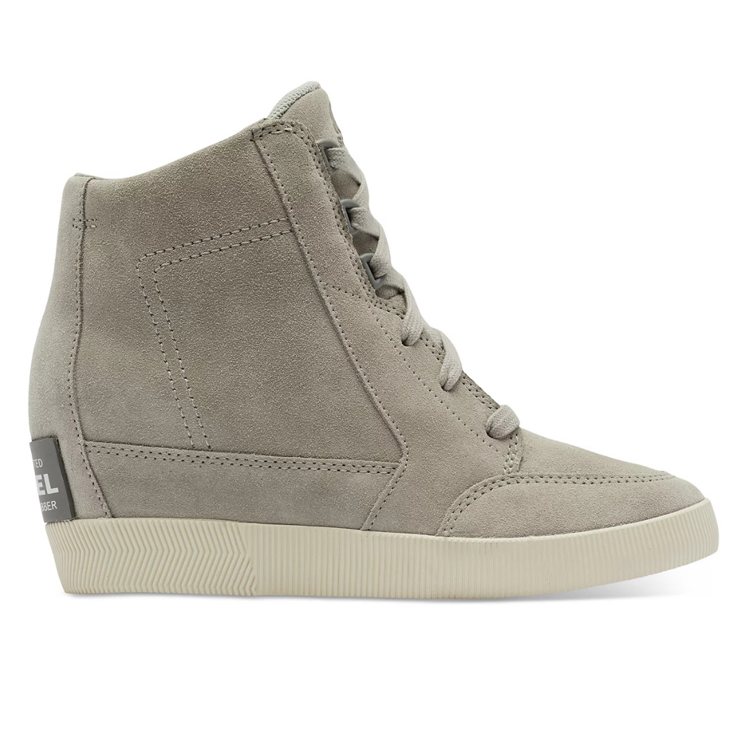 Sorel Out N About Shoe is a high-top sneaker with a suede upper in a light beige color, featuring a rubber sole and lace-up design for casual wear.