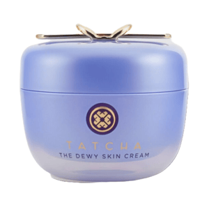Tatcha The Dewy Skin Cream is a purple jar with a gold emblem and lid, designed for moisturizing and providing a dewy glow to the skin.