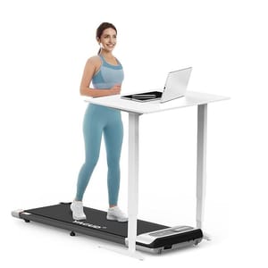 A woman is walking on a treadmill that is positioned under a standing desk with a laptop on it.