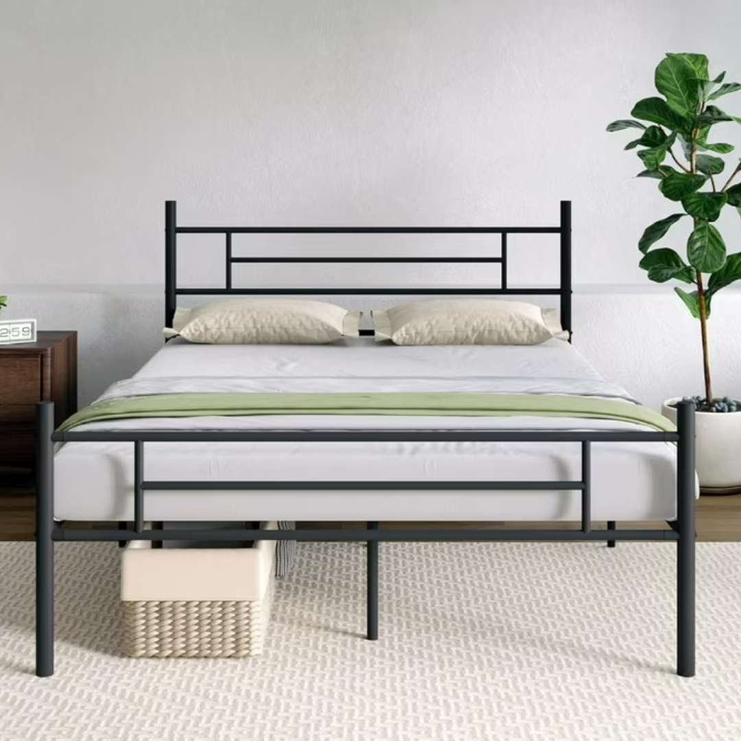 A modern black metal bed frame with a geometric headboard and footboard, shown with a neatly made bed with pillows and green accent, accompanied by a bedside table, a clock, and a potted plant.