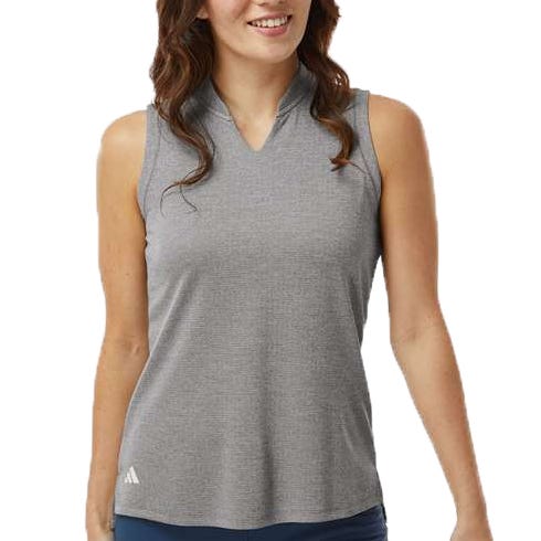 A woman is wearing a sleeveless gray top with a small logo on the lower left.