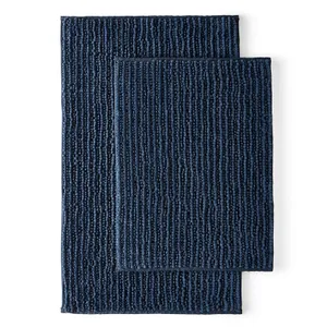 Two stacked navy blue bath rugs with textured patterns.