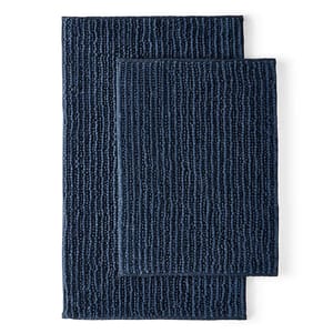 Two stacked navy blue bath rugs with textured patterns.