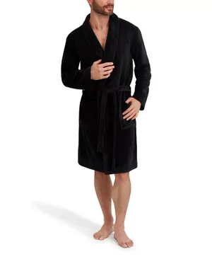 A man is wearing a black knee-length robe with a shawl collar and a belt at the waist. The robe also features two front pockets.