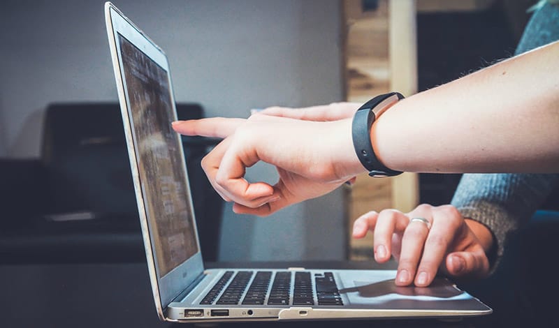 students pointing at laptop screen
