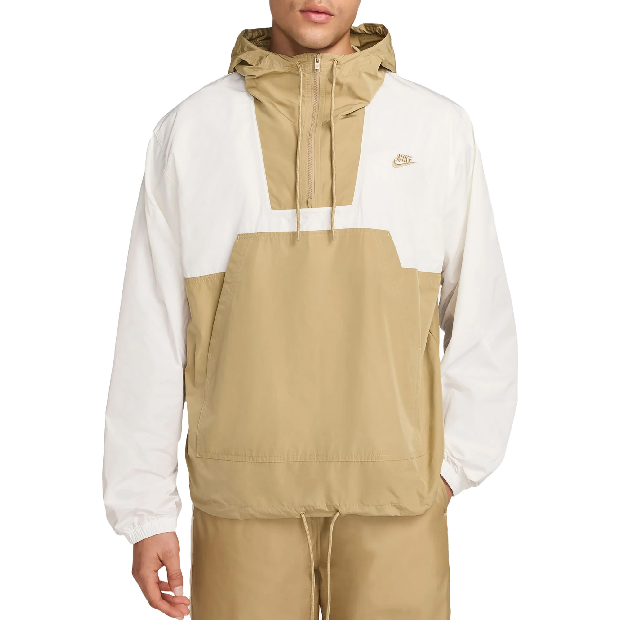 A Nike Men's Anorak Jacket in tan and white with a half-zip front, hood, and kangaroo pocket. The Nike logo is on the chest, and the cuffs are elasticized.